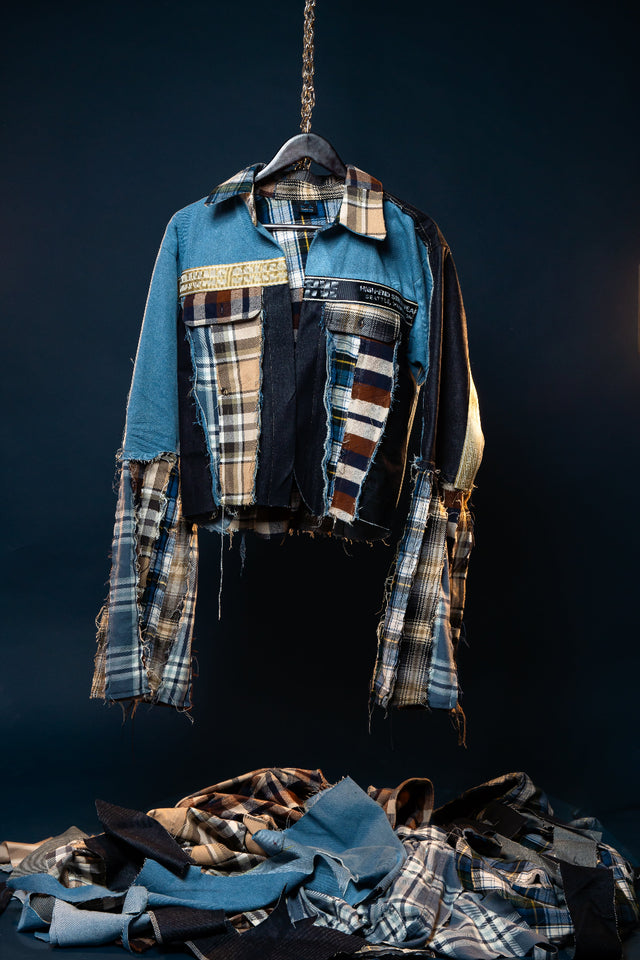 A Seattle-inspired patchwork jacket built from mixed denim, layered flannel, and signature Mediums detailing. The Seattle Fever Dream Flannel/Denim Jacket combines light blue and black denim with plaid and striped flannel panels for a bold reconstructed look rooted in Seattle streetwear style. Designed with a cropped silhouette, elongated flannel sleeve extensions, chest flap pockets, and raw exposed seams, this piece delivers texture, contrast, and movement from every angle.