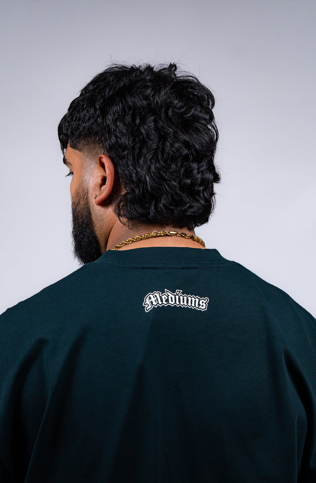 Familia graphic tee, Familia shirt, Mediums Collective tee, Latino streetwear, Mexican inspired clothing, family pride shirt, Gothic graphic tee, men’s streetwear shirt, Seattle streetwear brand, cultural streetwear, heritage graphic tee, pine green graphic tee, black Familia shirt, cream graphic tee, Latino fashion brand, Mexican American streetwear, family shirt, everyday graphic tee, men’s casual fashion.