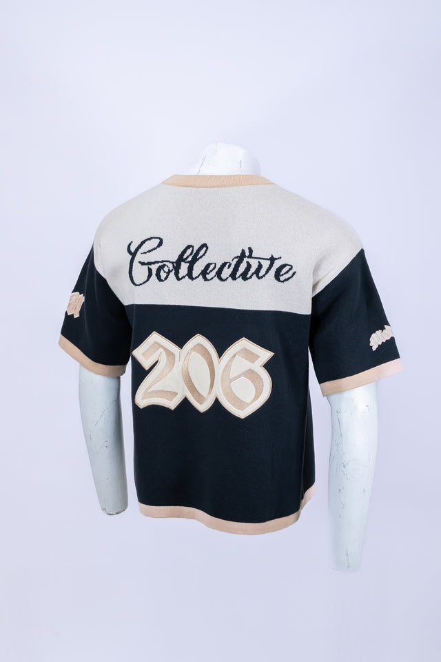 Mannequin wearing a beige and navy Mediums Collective SEA 206 Knit V neck sports jersey with a SEA Velour embroidery design on a white background. Baseball jersey with 'Collective' and '206' printed on a mannequin against a white background, beige and blue Mediums Collective Seattle 206 Knit V neck sports jersey with a SEA Velour embroidery design on a white background, MLB merch, mariners merch, Seattle v-neck, streetwear, sports knit jersey, near me