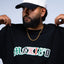 Person wearing a black 'MEXICO' t-shirt and white cap with text on a light blue background Mexico graphic tee, Mexico long sleeve shirt, Mexican streetwear, Latino streetwear, Mediums Collective, Seattle streetwear, Mexico shirt, Mexico soccer shirt, fútbol fashion, Mexican heritage clothing, men’s graphic tee, men’s long sleeve graphic shirt, pine green tee, black long sleeve shirt, white long sleeve shirt, cultural streetwear, World Cup outfit, Mexico capsule, Latino fashion brand, Mexican inspired appare